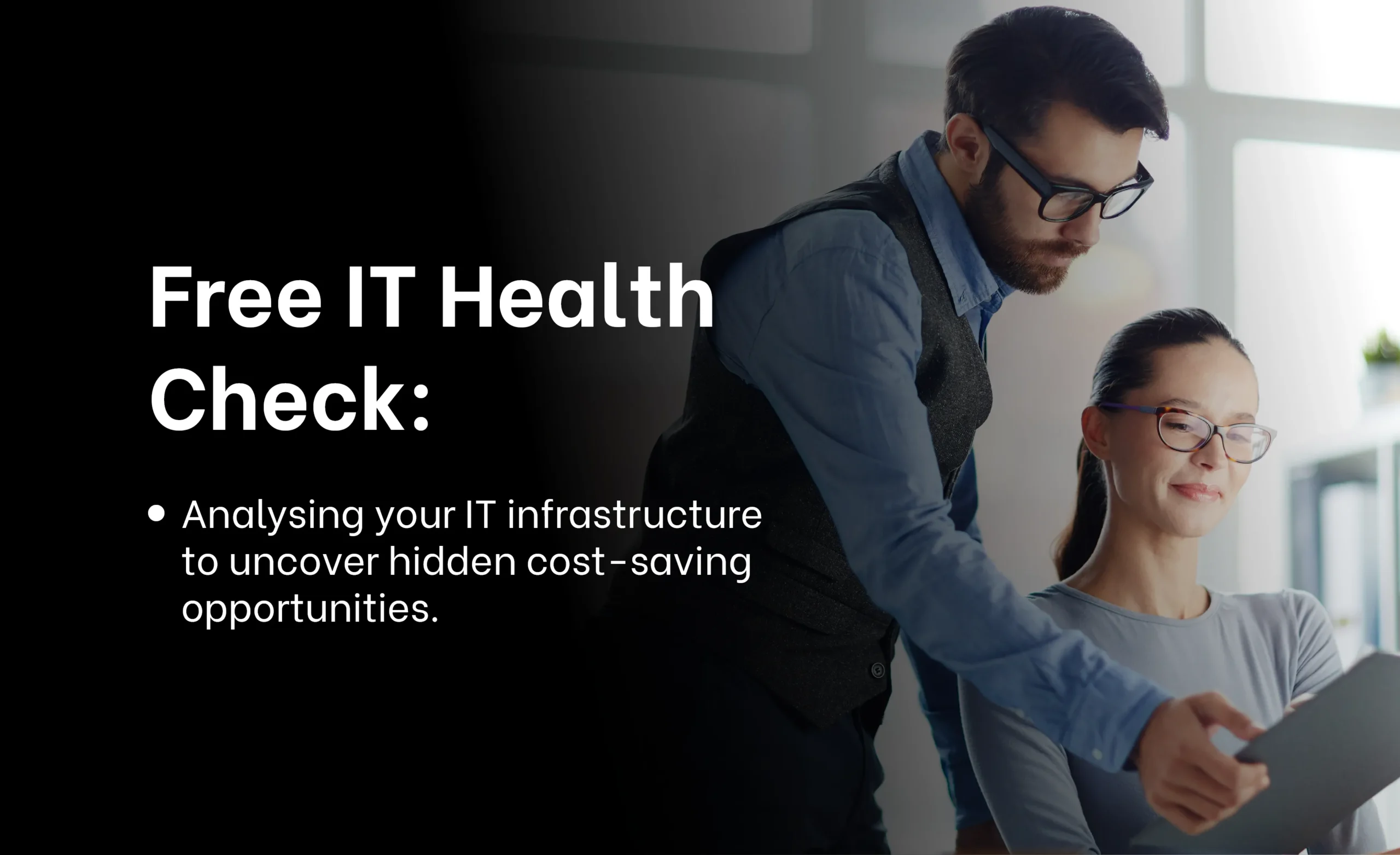 Two colleagues collaborating in an office setting, with a man showing a tablet to a smiling woman seated at a desk. The text on the left reads: 'Free IT Health Check: Analysing your IT infrastructure to uncover hidden cost-saving opportunities.