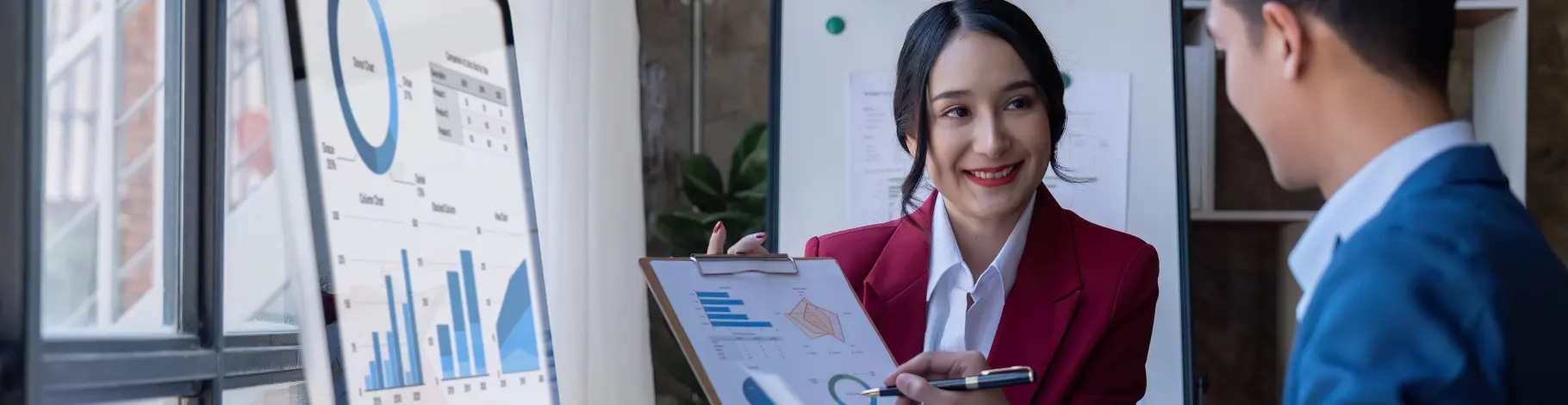 Businesswoman presenting analytical charts to a colleague, representing data solutions tailored for Australian enterprises