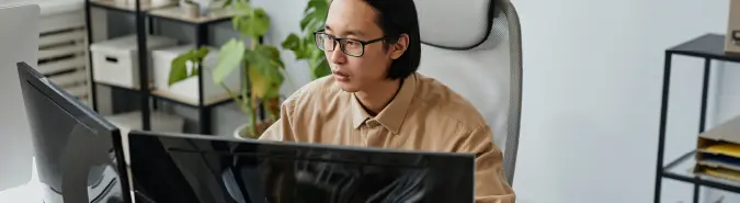 Professional using dual screens for Azure Virtual Desktop, representing scalable desktop virtualization solutions by Exigo Tech in Singapore