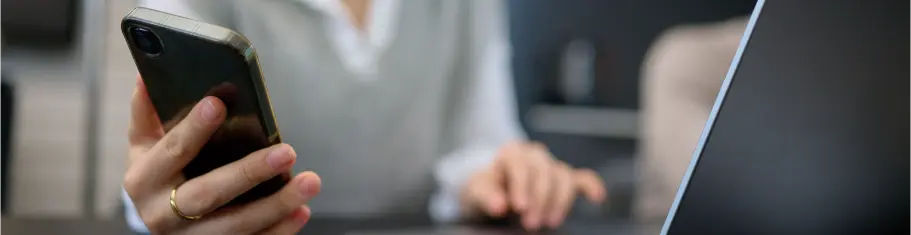 Person using a smartphone and laptop to explore modern apps provided by ExigoTech Singapore