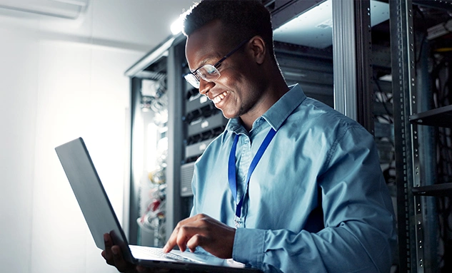 IT professional reviewing backup system on a laptop, representing Regular Backups as part of the Essential Eight strategy.